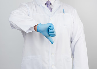 doctor in a white coat with buttons shows a gesture of dislike with his hand