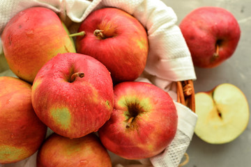 Red apples in a basket. Ripe apples in a wicker basket on a gray light background, top view.