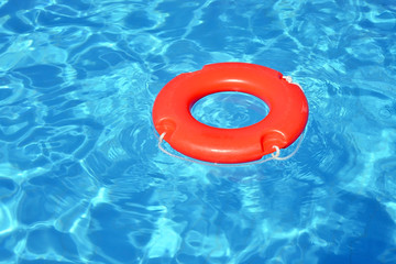 Colorful lifebuoy floating in swimming pool