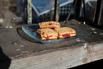 Cookies lie on a glass plate on an old cracked nightstand.