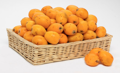 Nespole nel cesto su sfondo bianco