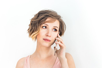 Close up Young Woman Talking to Someone on her Mobile Phone While Looking Into the Distance with Happy Facial Expression on white background