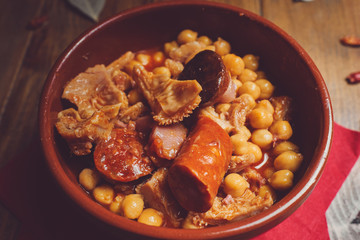 Garbanzos con callos en plato cerámico fondo madera