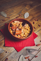 Garbanzos con callos en plato cerámico fondo madera