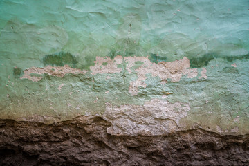Old grunged stone wall with fading green paint. Abstract.