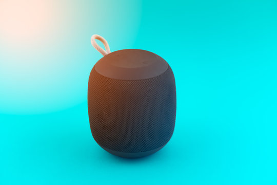 Portable speaker on blue background and flare