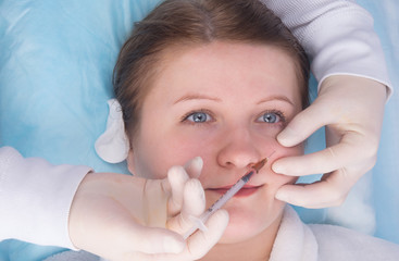 cosmetology, hands in sterile gloves make an injection of beauty to a woman, in the front part