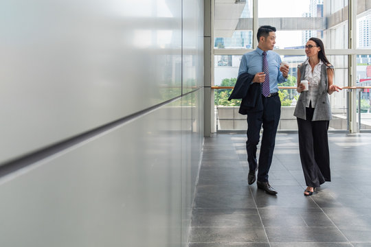 Business People Walking In Hallway With Big Windows Stock Photo