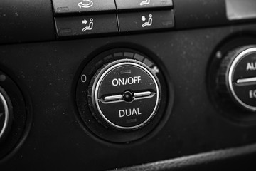 Close up photo inside a car, air conditioning buttons on and off.