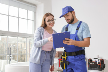 Portrait of woman and plumber in bathroom