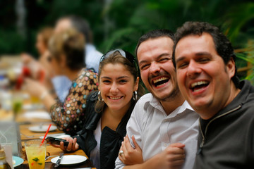 grupo de amigos sorrindo em mesa de restaurante