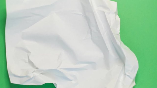 stop motion video animation white paper wrinkles making a paper ball on a green background