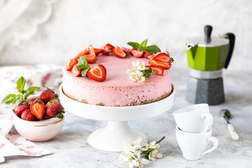 Cheesecake with fresh strawberries on a white table. Selective focus