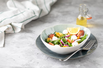healthy salad with arugula with yellow and red tomatoes and mozzarella.