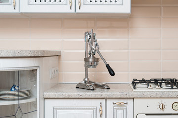 a steel pusher juicer press on the shelf at home in the kitchen
