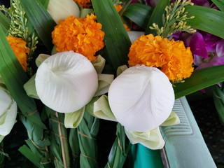 Closeup of beautiful white lotus and marigold flowers with green leaves. Beauty of nature concept.