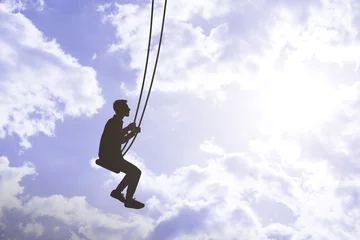 Keuken spatwand met foto flying high in the sky with clouds, man on a swing, relax and dream in mind concept © Mihail