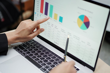 Asian accountant working and analyzing financial reports project accounting with chart graph and...