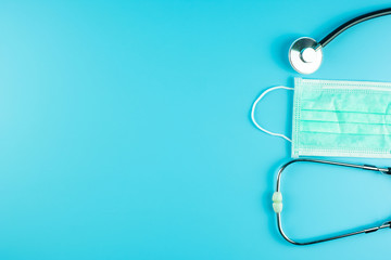 Top view Protective face mask and Stethoscope on blue background with copy space for text. Protection of Coronavirus , Covid-19 and Influenza. Antiseptic, World Health day and Happy Doctor day concept