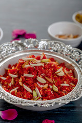  Gajar ka halwa is a sweet dessert pudding from India made from carrot, served in a bowl. Garnished with cashew, almond and pistachio nuts.