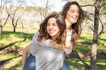 Naklejka premium dos chicas disfrutando de una tarde primaveral en un parque lleno de almendros en flor