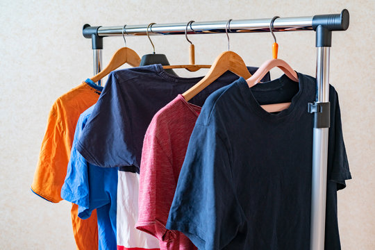 simple set of colorful t-shirts on a hanger at home near the wall, simple minimalist concept