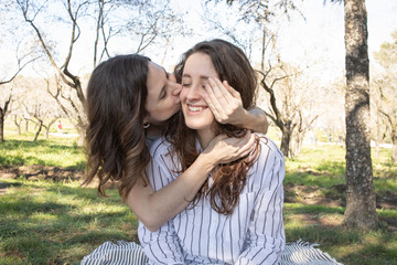 two young girls enjoying a spring day in an outdoor park surrounded by flowering trees