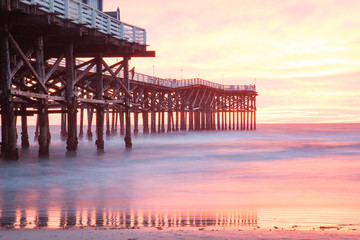Fototapeta na wymiar Sunset over the ocean next to pier