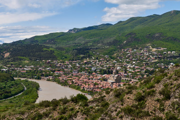 Fototapeta premium Panoramic view of Mtskheta (Mccheta) former capital city and one of oldest cities in Georgia on the bank of Kura river with Svetitskhoveli Cathedral Temple (Sweti Cchoweli)