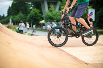 Fototapeta premium Bmx rider jumping over on a U ramp in a skatepark (motion blurred image)
