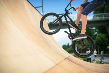  Bmx rider jumping over on a U ramp in a skatepark (motion blurred image)