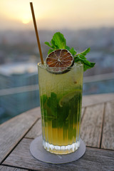 A glass of mojito with dried lime and fresh mint