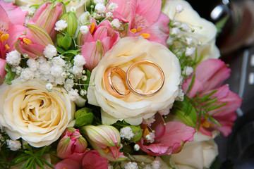 rings in the bride's bouquet of pink and white roses