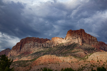 Sunlight through the storm clouds on sandstone mountains in Zion National Park