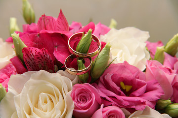 rings in the bride's bouquet of pink and white roses