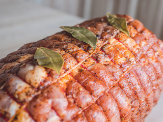 Close-up view of raw meatloaf. Uncooked spicy meat roulade prepared to roast, marinated with spices and herbs.