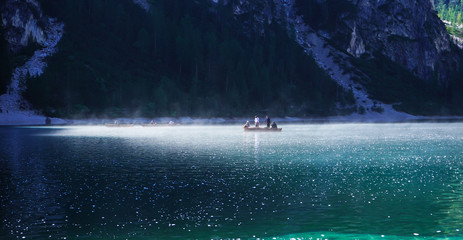 Braies Lake In Trentino Alto Adige: people on a small boat, background with lots of light spots