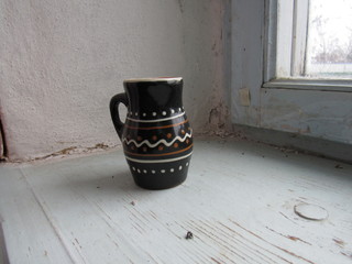 a little empty black jug on the windowsill