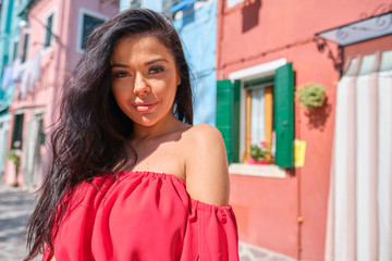 Fashion woman portrait in red dress outside. WOman brunette smiling happy looking at camera.  outdoor shoot