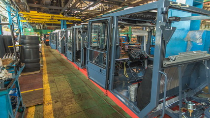 Conveyor assembly stage the body of tractor at factory timelapse
