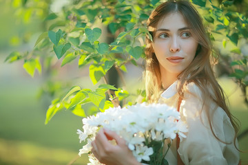 girl holding a bouquet of flowers a walk in the park / romantic young beautiful cute model, love feelings gift
