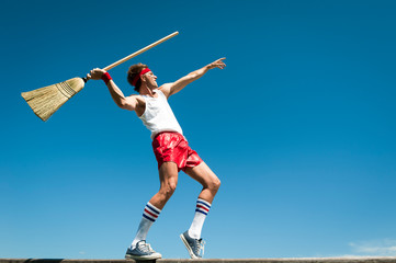 Nerd athlete throwing broom as javelin in his own special version of a track and field event