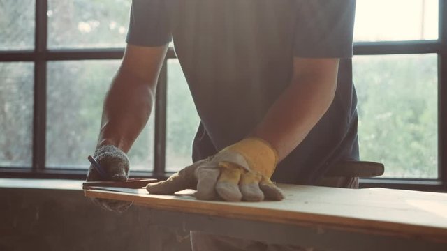 4k slow motion Shoot.Professional Carpenter working on woodworking machines in a workshop of wood factory. Entrepreneur small business owner working in the workspace.