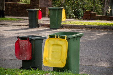 Australian garbage wheelie bins with colourful lids for general and recycling household waste lined...