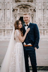 groom and bride posing in front of the church
