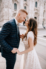 groom and bride posing in front of the church