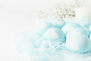 Easter. Holiday. Light white background, gentle pastel colors. Blue eggs with image of rabbit