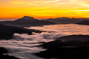 Detail of the beautiful Mount Larrun on a winter morning by the sea of clouds at the golden hour. Basque Country