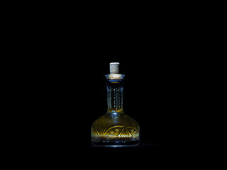 Vintage carafe with homemade vodka on the dark background. Alcoholic drink hrenovuha in transparent vintage bottle.