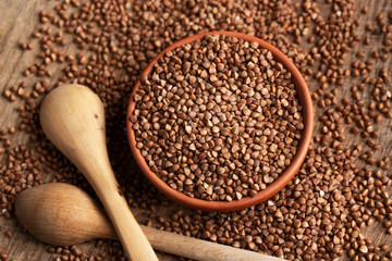 Buckwheat in bowl on table, spoons, top view 